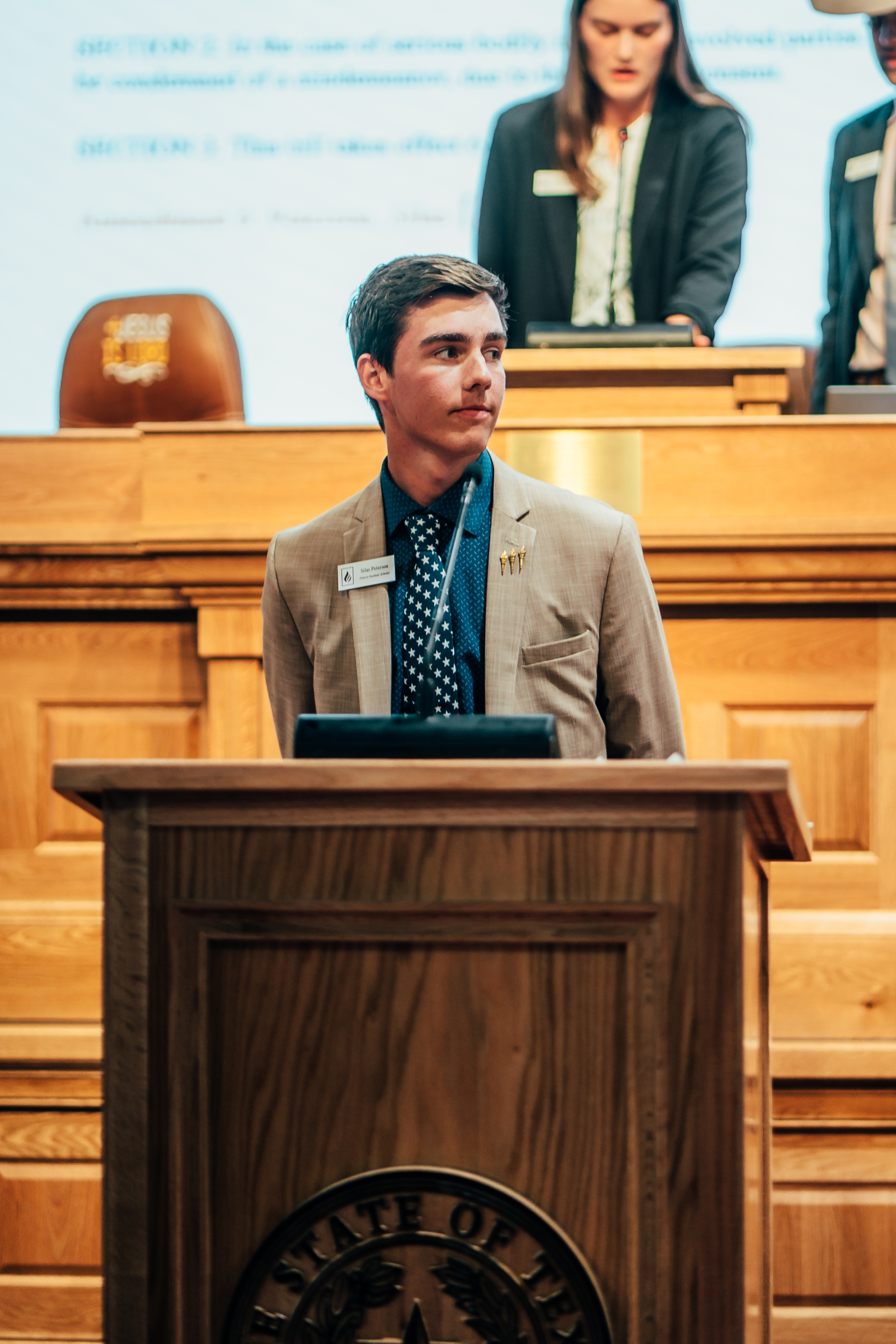 Patriot Institute Scholar speaking from a legislative desk